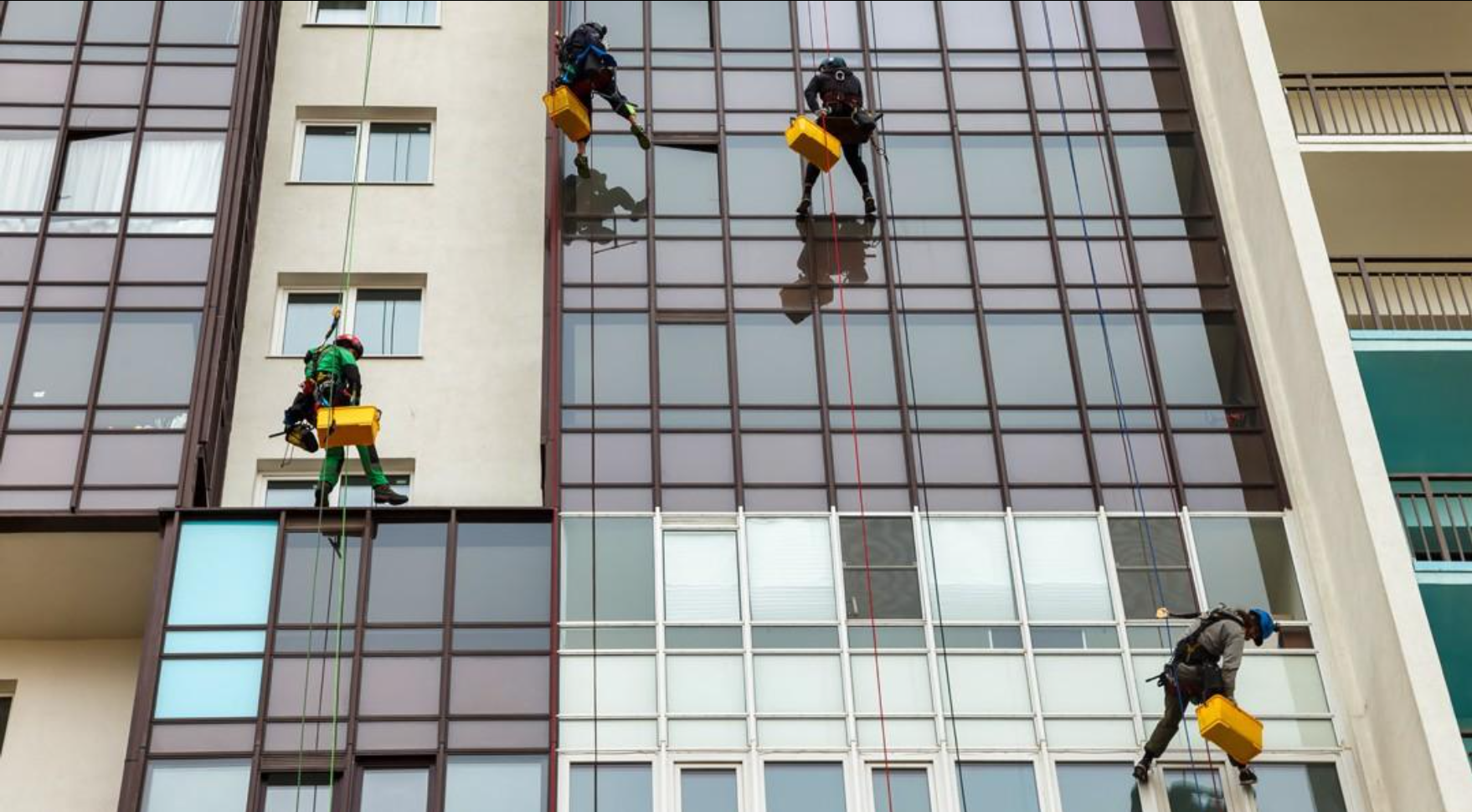 Traditional manual cleaning operation with workers suspended at height