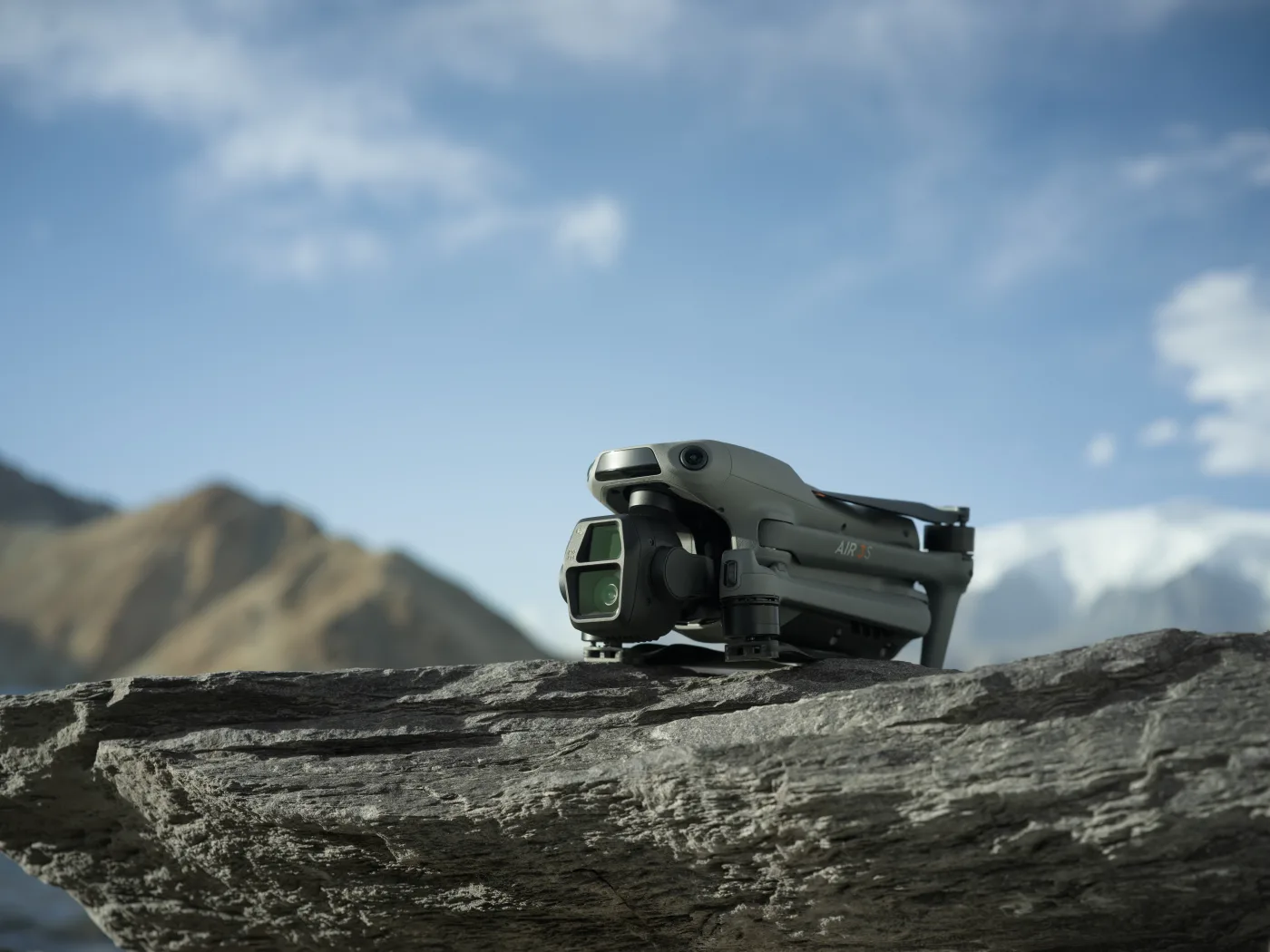 DJI Air 3S camera drone staged on rock in a mountain setting