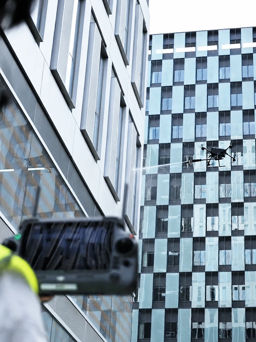 Matrice 400 using the HoverWash 3 smart washing kit on a commercial facade